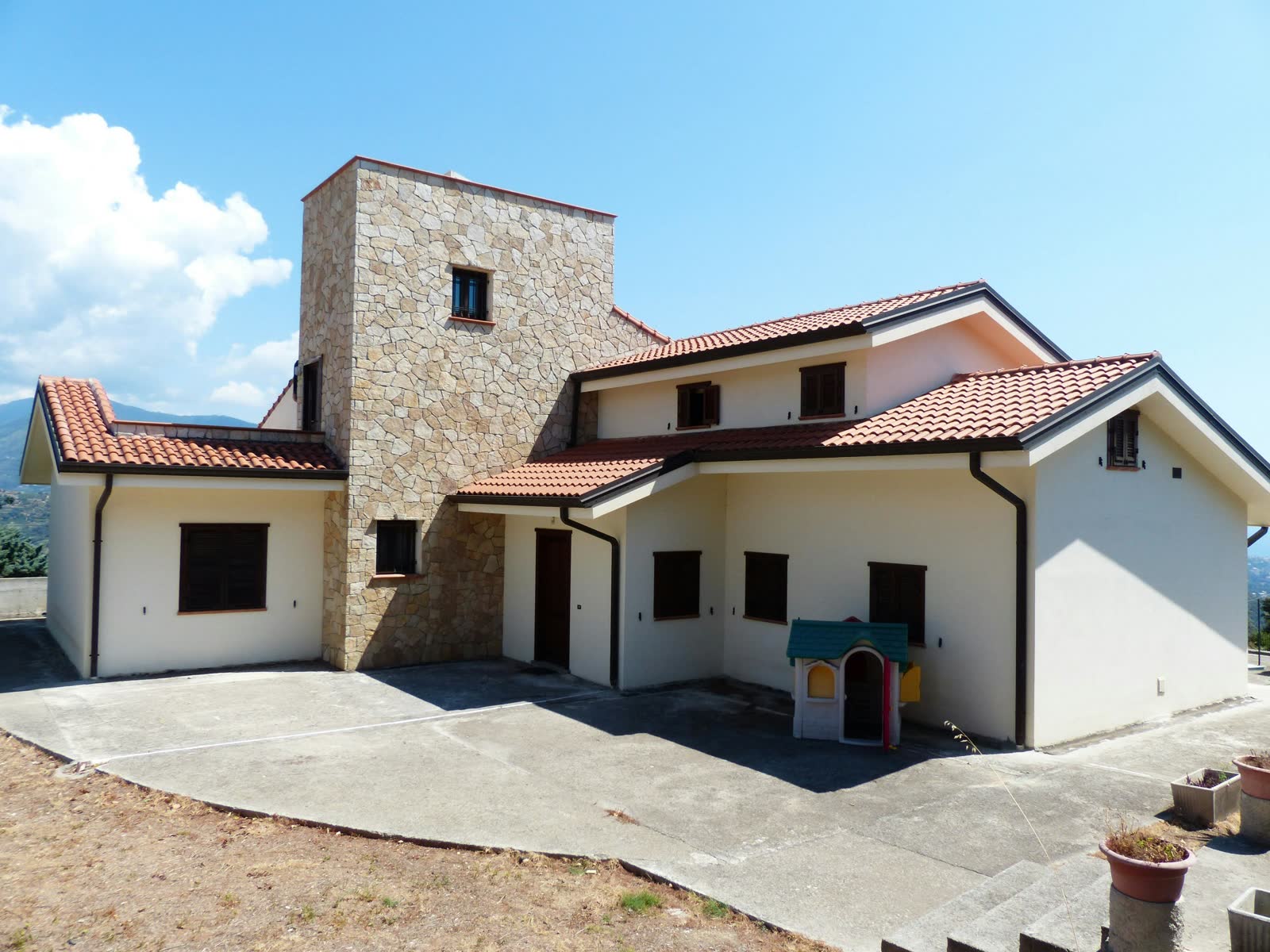 Villa siciliana con tetto in tegole e torre rivestita in pietra